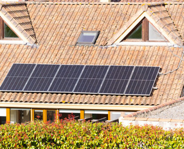 A house with a solar panel on the roof. The solar panel is made up of four panels